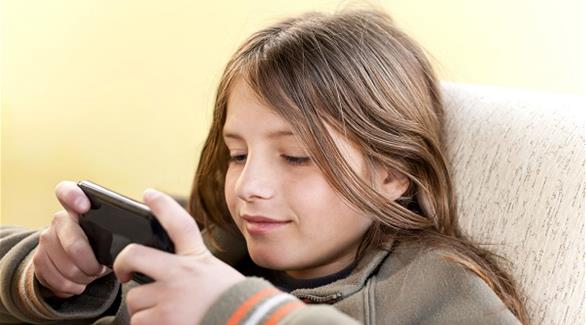 صورة تعبيرية لطفلة تستخدم الموبايل 