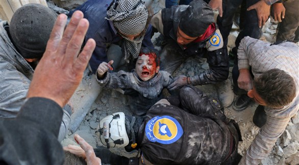 عمال الدفاع المدني السوري لحظة انتشال طفل من الدمار في حلب (أ ف ب)