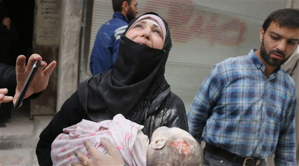 امرأة تحمل جثة ابنتها بعد مقتلها بغارات النظام الأسد وحلفائه (أ ف ب)