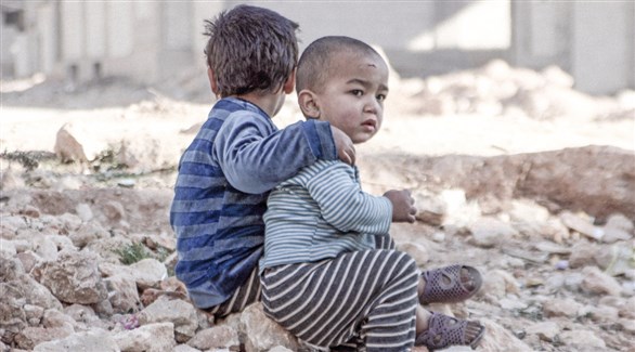 أطفال من سوريا يجلسون على ركام أحد المباني المتضررة (يونيسيف)