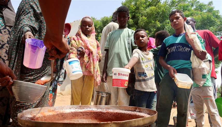 عائلات سودانية تبحث عن الغذاء والماء (رويترز)