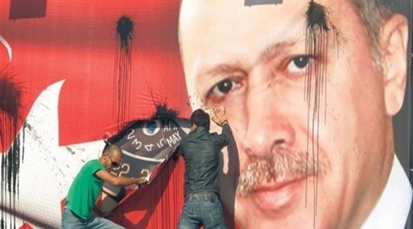 تركيان يمزقان صورة للرئيس التركي رجب طيب أردوغان (أرشيف)