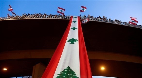 متظاهرون يرفعون العلم اللبناني على جسر جل الديب شمالي بيروت (أرشيف / رويترز)