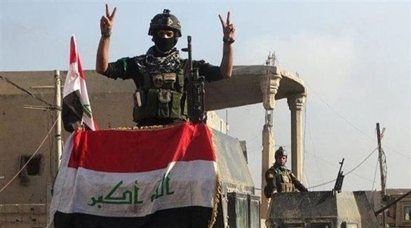 جندي عراقي يرفع شارة النصر في الذكرى الأول لإعلان هزيمة داعش (أرشيف)