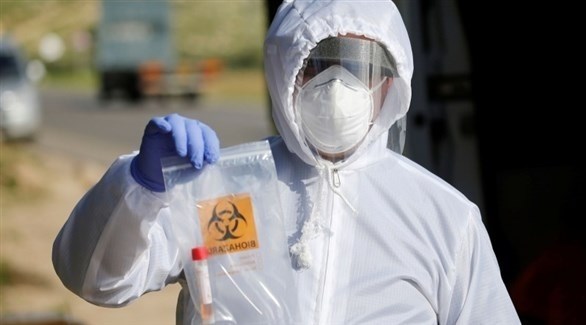 عامل في المجال الصحي يحمل عينة من فيروس كورونا (أرشيف / رويترز)