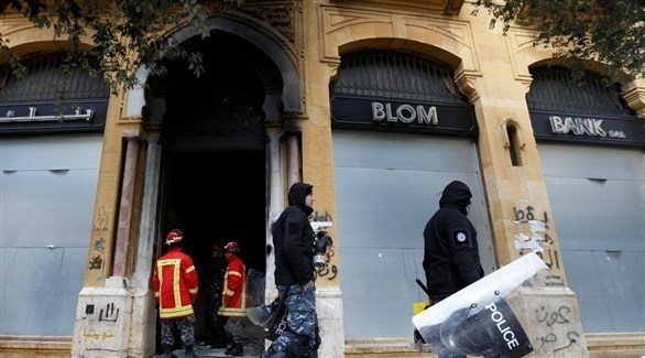 عناصر أمنية تمر بجانب فرع محترق لاحد المصارف في بيروت (أرشيف)