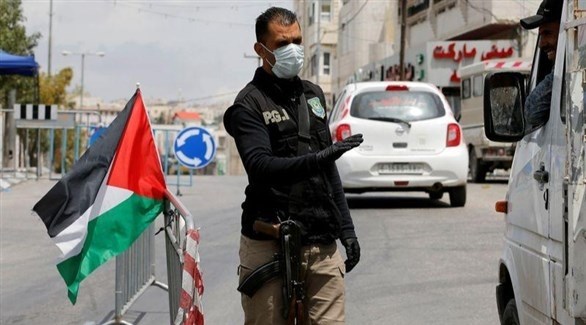 رجل أمن فلسطيني يرتدي كمامة في رام الله (رويترز)