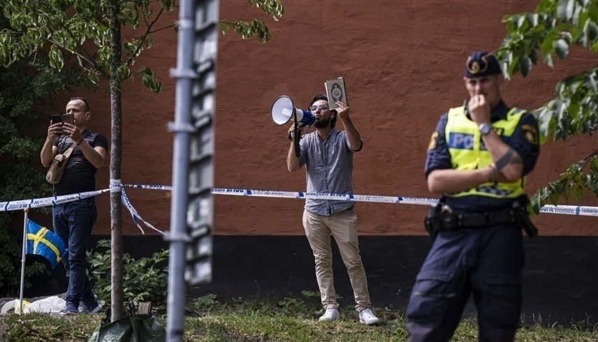 المهاجر العراقي يرفع مصحفاً قبل إحراقه في السويد (ا ف ب)